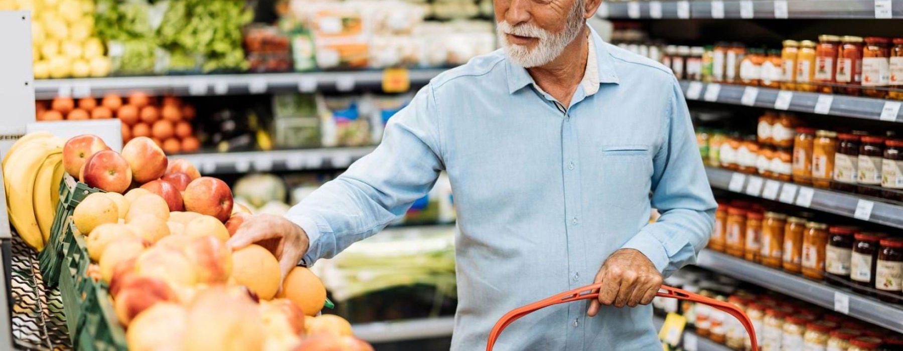 a person holding a shopping cart in a grocery store