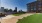 a large grassy area with buildings in the background