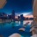 a pool with chairs around it and a city in the background